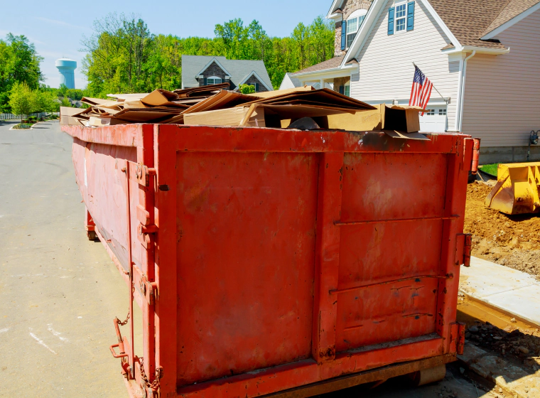 orange dumpster with cardboard boxes inside